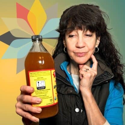 Adrienne from Whole New Mom holding a bottle of Bragg apple cider vinegar for the Whole New Mom product review.